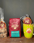 Java Love coffee products including a mug, coffee beans, and a bag on a wooden surface with a dark background.