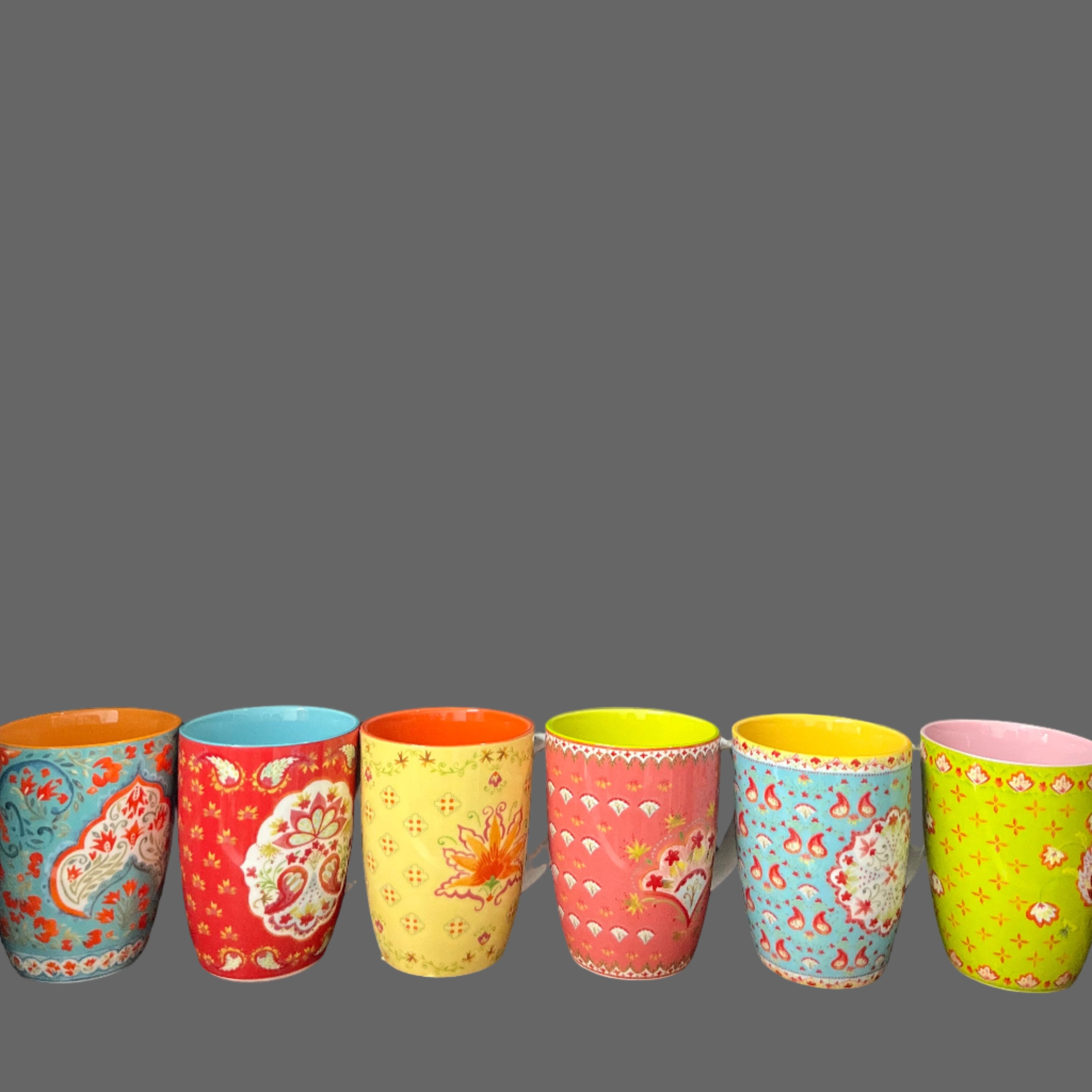 Set of colorful patterned mugs on a wooden surface with a chalkboard background